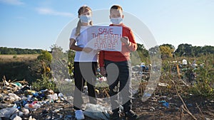 Little boy and girl hold in hands poster of environmental movement for saving earth. Small eco volunteers in protective