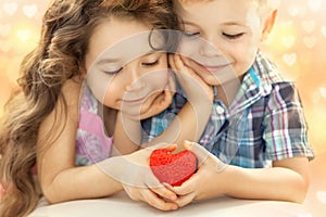 Little boy and girl holding in hands red heart