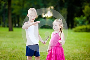 Little boy and girl with ladybird in park