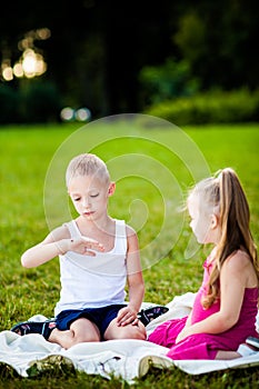 Little boy and girl with ladybird in park