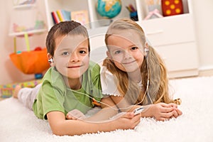 Little boy and girl listening to music together