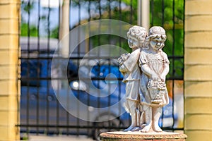 Little boy and girl, old sculpture. Background with selective focus and copy space
