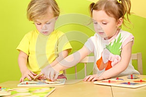 Little boy and girl with pigtails playing a board