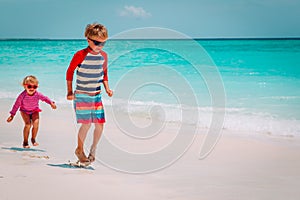 Little boy and girl play at beach, kids have fun on vacation