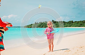 Little boy and girl play beach tennis on vacation