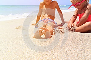 Little boy and girl play with water on beach