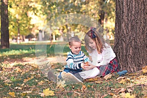 Little boy and a girl are playing outside