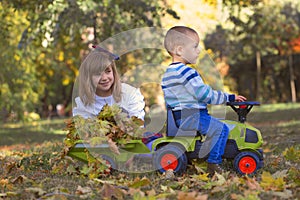 Little boy and girl playing in the park on a beautiful autumn da