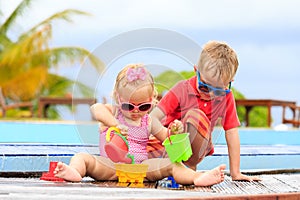 Little boy and girl playing in swimming pool at