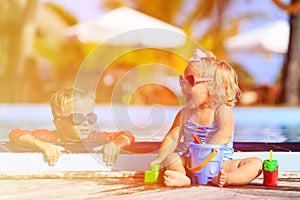 Little boy and girl playing in swimming pool at beach