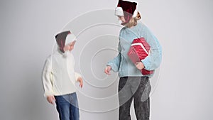 Little boy and girl with present in santa claus cap. Concept Christmas and New Year