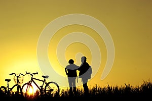 Little boy and girl riding bikes at sunset, active kids sport, Asian kid,Silhouette a kid at the sunset, Happy time.