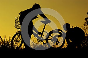 Little boy and girl riding bikes at sunset, active kids sport, Asian kid,Silhouette a kid at the sunset, Happy time.