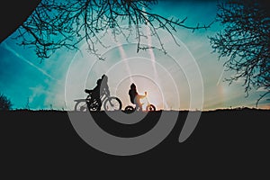 Little boy and girl riding bikes in sunset nature