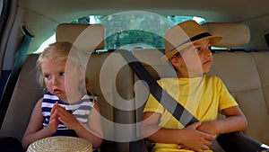 Little boy and girl are riding in the car and talking to each other