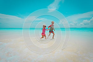 Little boy and girl run at beach, kids play on vacation