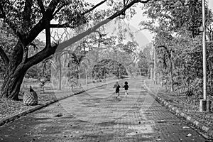 Little boy and girl running in joy in natural environment, black and white photograph of friendship