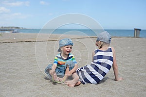Little boy and girl sitting on the beach