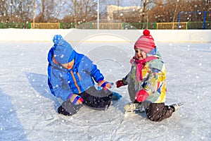 Little boy and girl skating together, kids winter sport