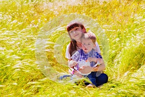 Little boy and girl in the summer field with flowers