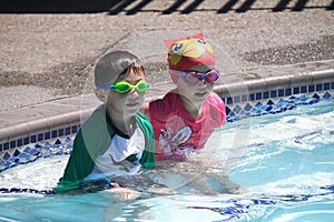 Little boy/girl twins ready to swim in pool