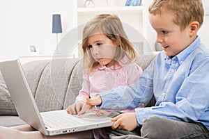 Little boy and girl using laptop