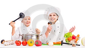 Little boy and girl with vegetables for soup on table