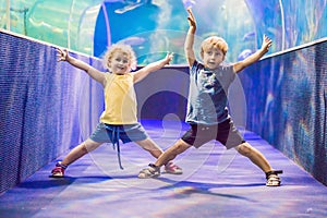 Little Boy and girl watching tropical coral fish in large sea life tank. Kids at the zoo aquarium