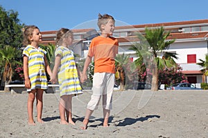 Little boy and girls standing on beach