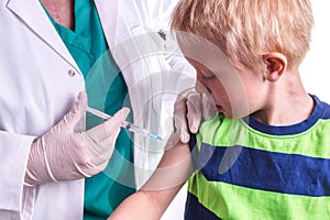 Little boy is given an injection by the family doctor