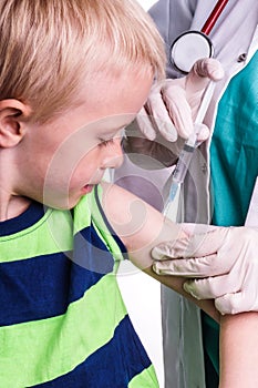 Little boy is given an injection by the family doctor