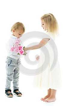 A little boy gives a girl a bouquet of flowers. The concept of l