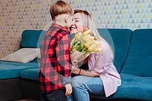 a little boy gives his mother flowers