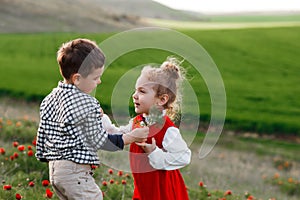 A little boy giving flowers to a girl. The concept of love