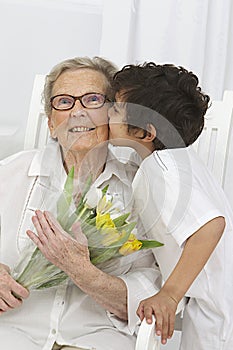 Little boy giving flowers to his grandmother