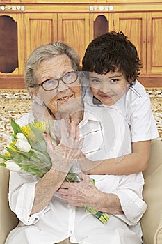 Little boy giving flowers to his grandmother