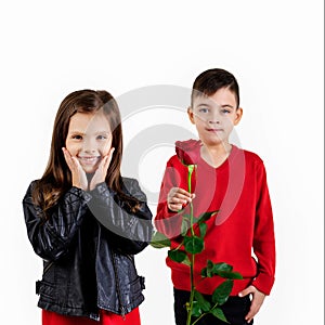 Little boy giving a red rose to child girl