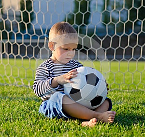 Little boy in the goal with his soccer ball photo