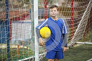 Little boy in goalkeeper uniform on football field. Sport.