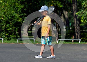Little boy  goes to play badminton with badminton rackets in the back