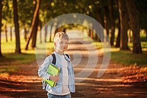 Little boy going back to school. Child with backpack and books.