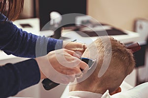 Little boy at the hairdresser. Child is scared of haircuts. Hair