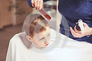 Little boy at the hairdresser. Child is scared of haircuts. Hair