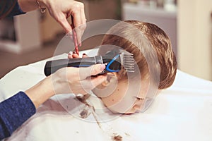 Little boy at the hairdresser. Child is scared of haircuts. Hair