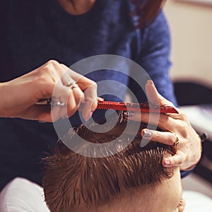 Little boy at the hairdresser. Child is scared of haircuts. Hair