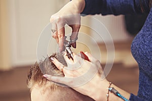 Little boy at the hairdresser. Child is scared of haircuts. Hair