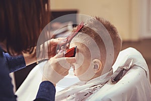 Little boy at the hairdresser. Child is scared of haircuts. Hair