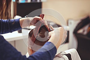 Little boy at the hairdresser. Child is scared of haircuts. Hair