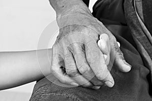 little boy hand touches and holds an old man wrinkled