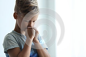 Little boy with hands clasped together for prayer